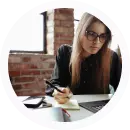 Mujer joven revisando documentos y usando computadora portátil en proceso de aplicación laboral