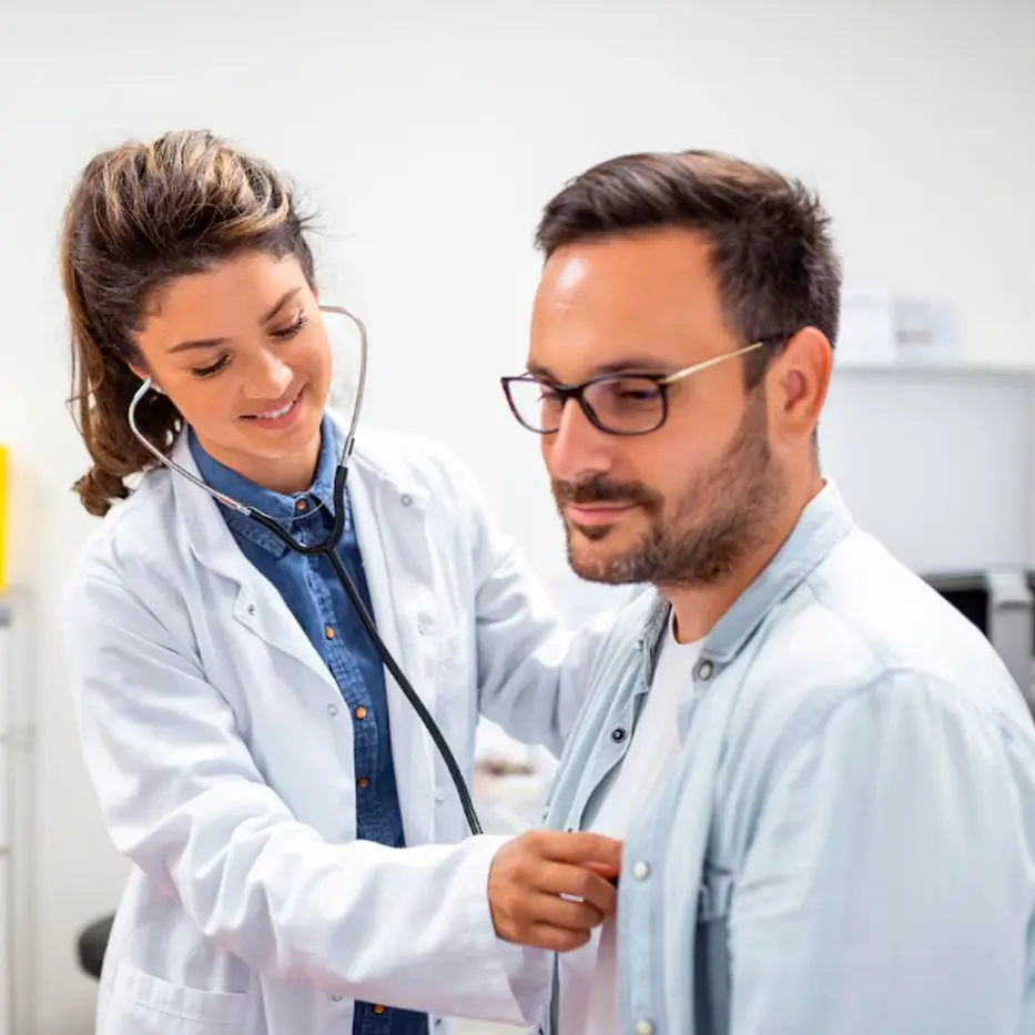 Médico usando un estetoscopio Welch Allyn para auscultar a un paciente durante una revisión médica.