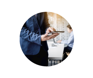 Ejecutivo usando una tablet mientras un colega trabaja en el fondo en una oficina moderna.