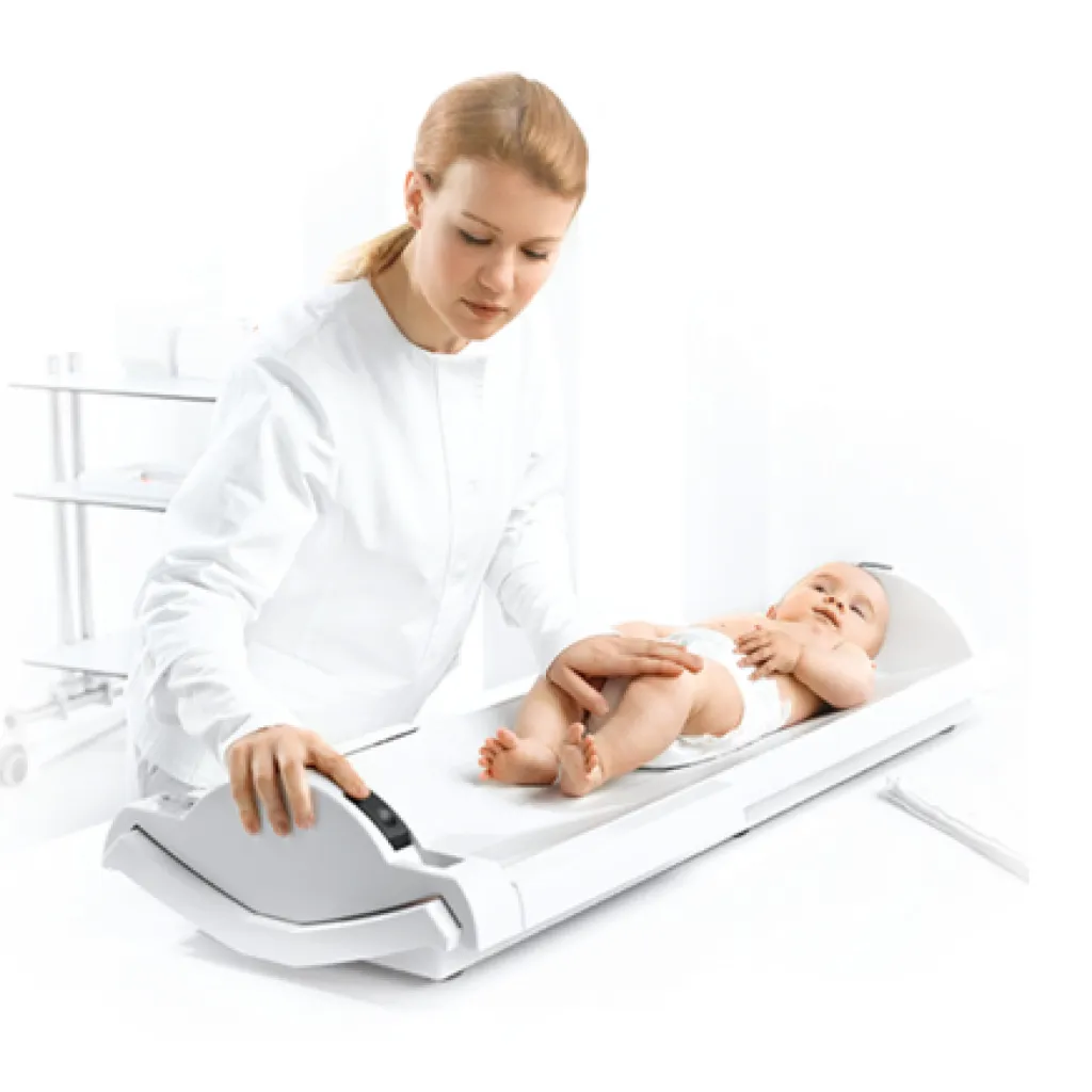 Médica controlando el peso de un recién nacido en báscula digital Seca.