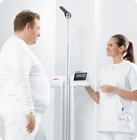 Paciente adulto siendo medido por personal médico con tallímetro electrónico Seca.